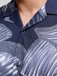 Details van de kraag en knopen van een blauw overhemd met abstracte grijze bladprint.