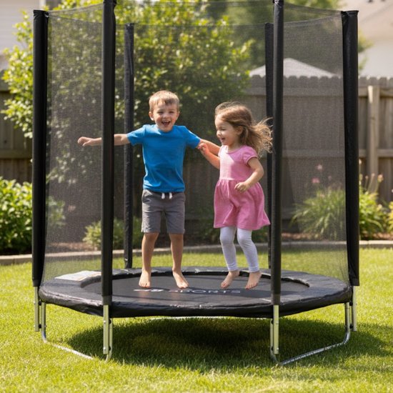 Jongen in blauw shirt en grijs short en meisje in roze jurk springen op ronde trampoline met veiligheidsnet.