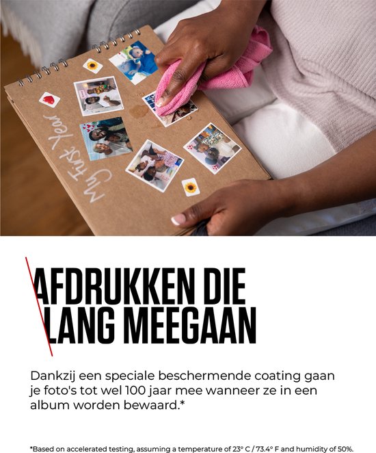 Une femme colle des photos dans un album intitulé 'My First Year', soulignant le revêtement protecteur spécial.