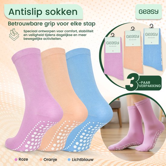 Drie paar antislip sokken in het roze, oranje en lichtblauw met witte noppen op de zool.