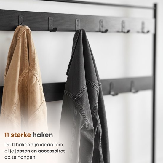 Twaalf zwarte haken op een zwarte wandmontage van het garderoberek, twee jassen hangen eraan.