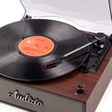 Close-up van een retro platenspeler met houtlook. Een vinylplaat met oranje label is zichtbaar.