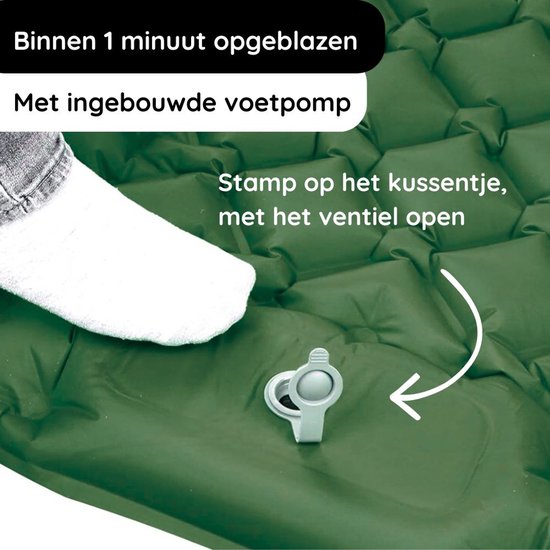 Voet van persoon stapt op groene slaapmat met ingebouwde pomp. Snel op te blazen.