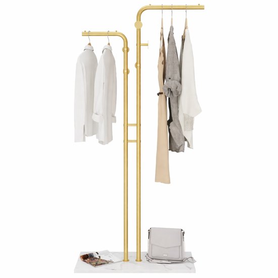 Gouden staande kapstok met marmeren voet, met witte kleding, een tas en een tijdschrift.