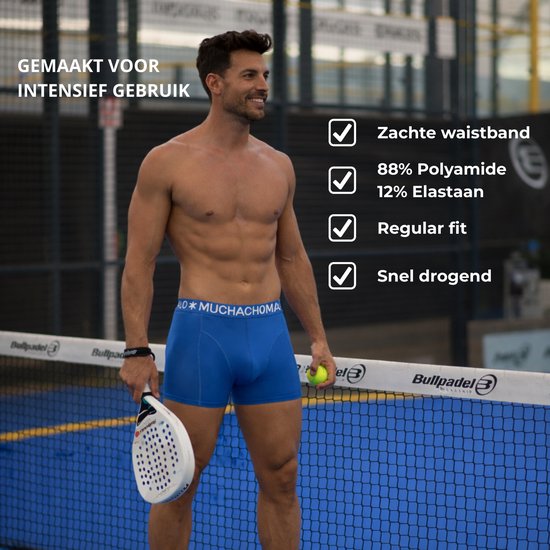 Man met spierbuik in blauwe boxershort op padelveld. 'Gemaakt voor intensief gebruik'.