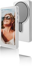 Witte magnetische selfie spiegel met reflecterend oppervlak, naast smartphone.