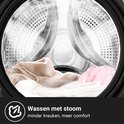 Intérieur du tambour de lave-linge avec du linge doux et à la vapeur, comme des pulls et des couvertures.