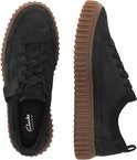 Boven- en zijaanzicht van zwarte suède sneakers met bruine, geribbelde zolen.