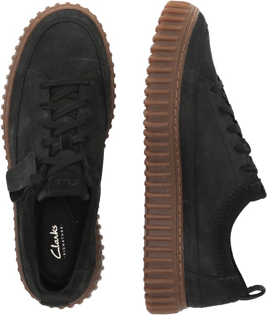 Boven- en zijaanzicht van zwarte suède sneakers met bruine, geribbelde zolen.