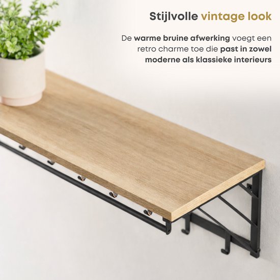 Close-up van een houten plank op een wandkapstok met een vintage look en zwarte haken.