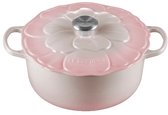 Zijaanzicht van een roze Le Creuset braadpan, deksel sluit de pot.