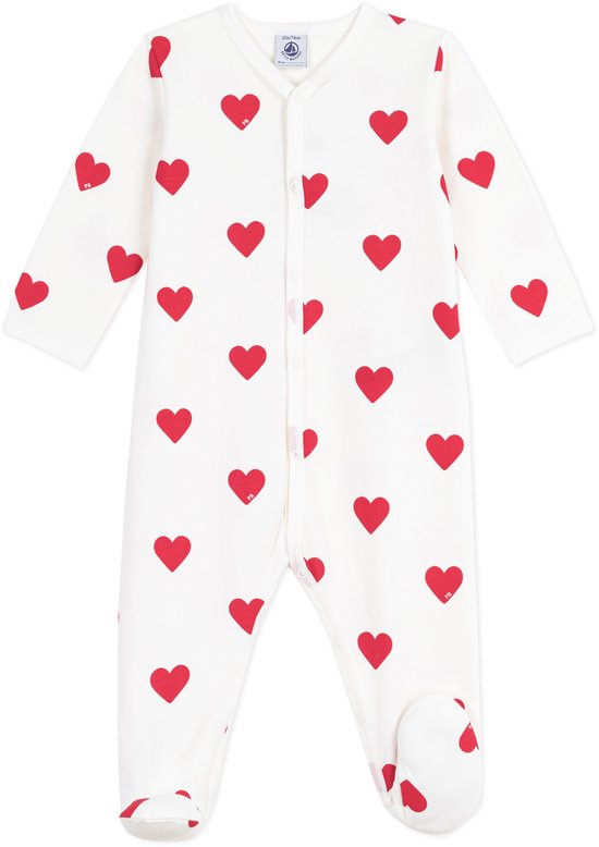 Pyjama blanc à imprimé cœur rouge avec pieds. Manches longues et fermeture boutonnée sur le devant.