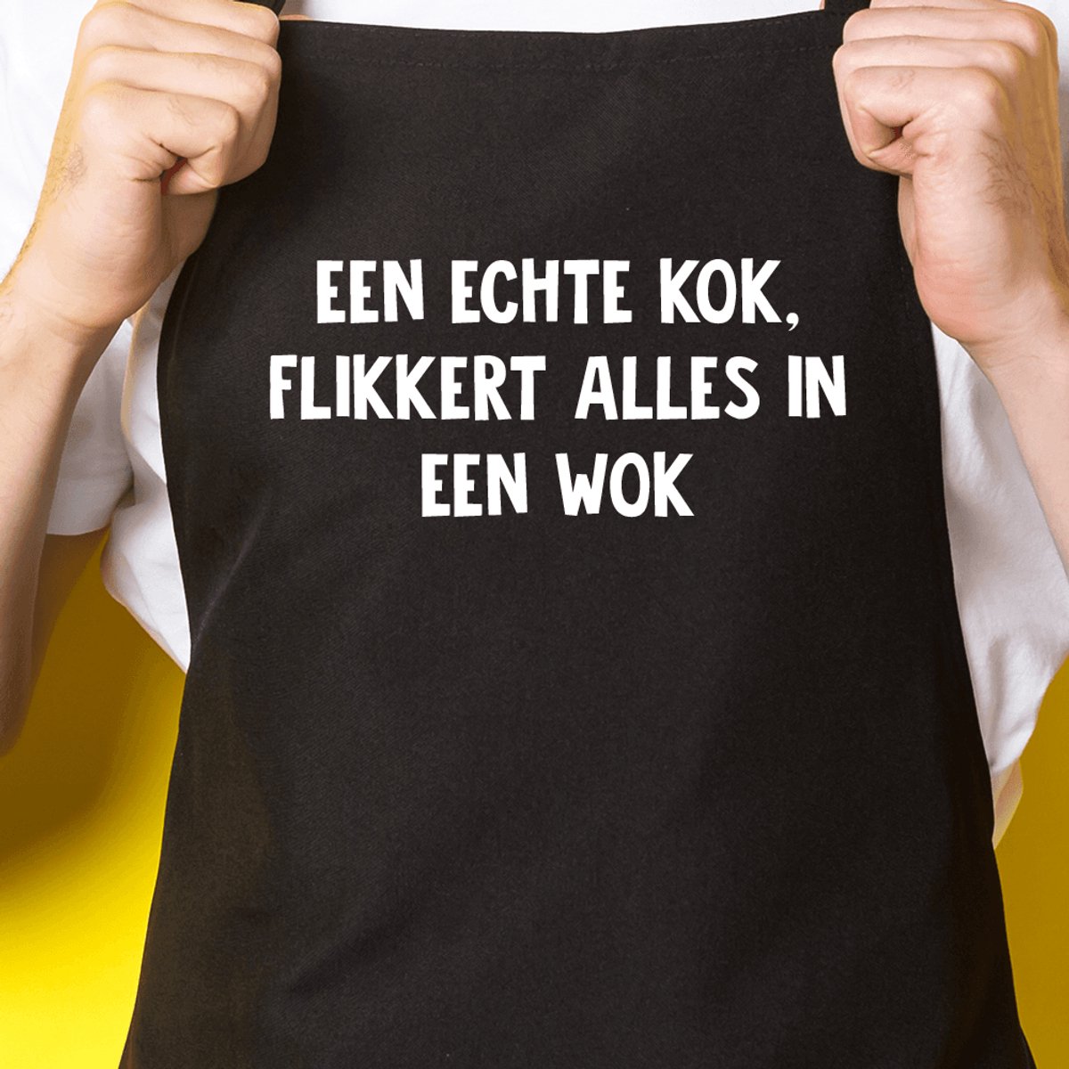 Zwart keukenschort / BBQ-schort met tekst | Een echte kok flikker alles in een wok | Katoen - One size - Verstelbaar - Wasbaar - Cadeau voor hem - Vaderdag - Gratis verzending - Cadeau voor Kerst & sinterklaas | Incl. 2 jaar garantie