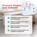 Witte naaimachine met rode accenten op een houten tafel, naast een stoffen runner.