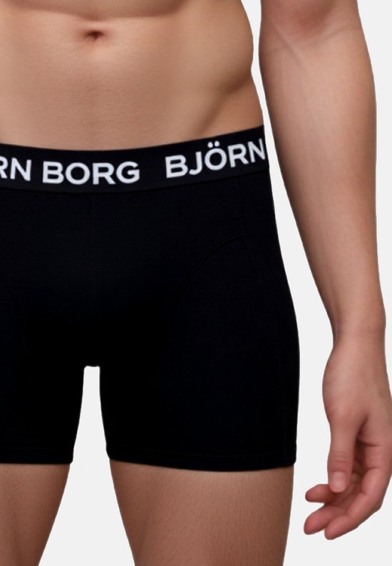 Detail van een zwarte Björn Borg boxer met witte merknaam op de band, gedragen door een man.