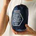 Handen die een donkerblauwe, opvouwbare jas tonen met 'WOMEN'S PACK-IT JACKET WATERPROOF & BREATHABLE' erop.