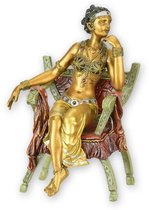 UNE SCULPTURE EN BRONZE D'UNE FEMME ASSISE SUR UNE CHAISE CURULE