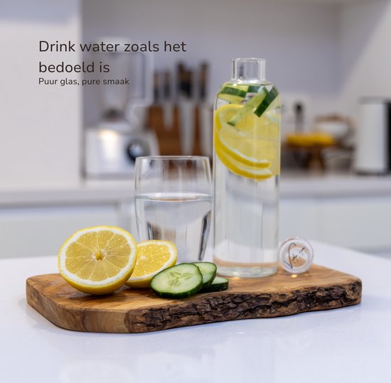 Glazen fles met citroen en komkommer, naast een glas water op een houten plank.