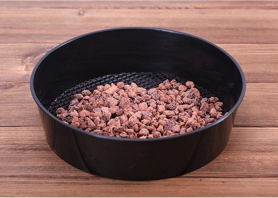 Zwarte ronde zeef gevuld met bruine steentjes.