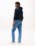 Blauwe jeans met lichte wassing, gedragen door een man van achteren.