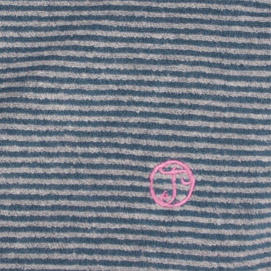 Close-up van een zacht gestreepte stof met een roze geborduurd logo.