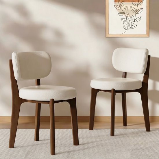 Twee crème wit leren eetkamerstoelen met bruine houten poten.