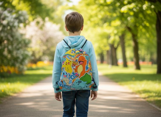 Jongen met lichtblauwe hoodie en rugzak met Pokémon-personages zoals Pikachu, Charmander, Squirtle en Bulbasaur.