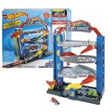Hot Wheels Stunt Garage speelgoed in de verpakking, naast de opgebouwde blauwe garage met oranje elementen en veel speelgoedauto's.