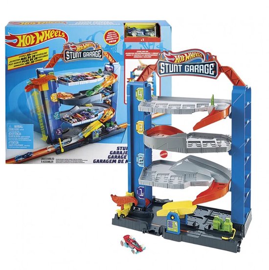 Hot Wheels Stunt Garage speelgoed in de verpakking, naast de opgebouwde blauwe garage met oranje elementen en veel speelgoedauto's.