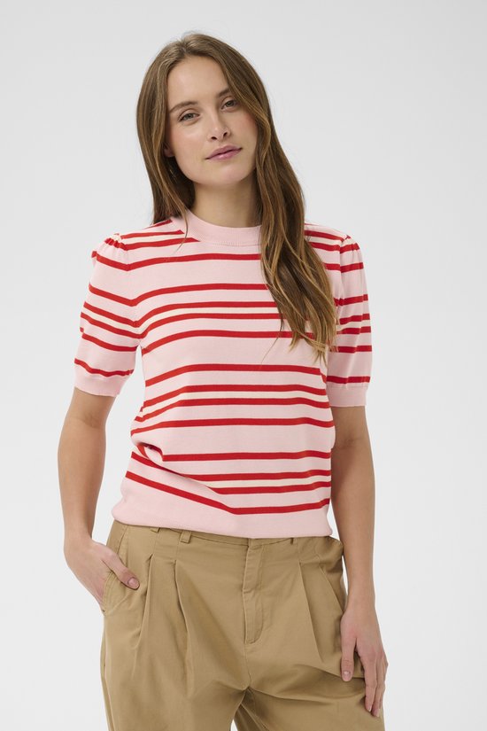 Vrouw, model, draagt roze trui met rode en witte strepen, beige wijde broek.