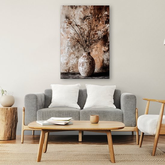 Gedroogde bloemen in vaas canvas, hangend boven een grijze bank in een woonkamer interieur.