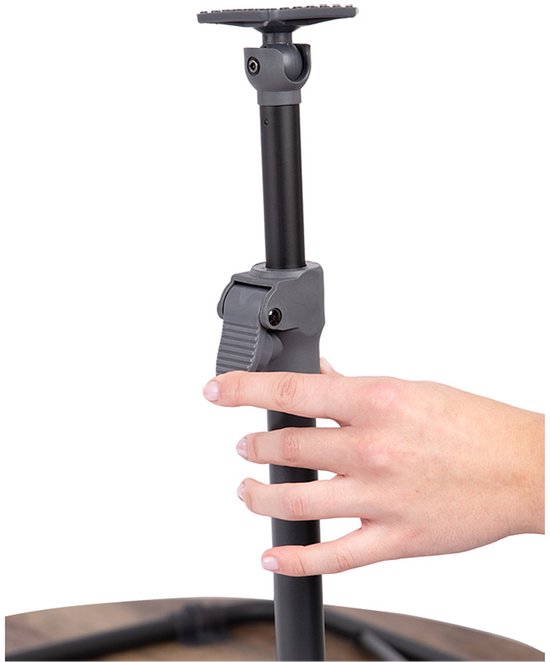 Hand past de hoogte van een zwarte metalen tafelpoot aan met een grijze klem.