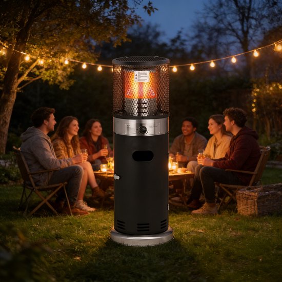 Zwarte staande terrasverwarmer met zilverkleurige details, met vlammen in de glazen buis, op een grasveld bij nacht.