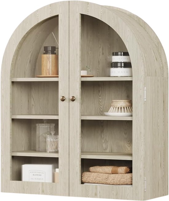 Boogvormige lichtgrijze wandkast met houten nerf, met glazen deuren en vier legplanken, gevuld met badkamerartikelen zoals potjes en handdoeken.
