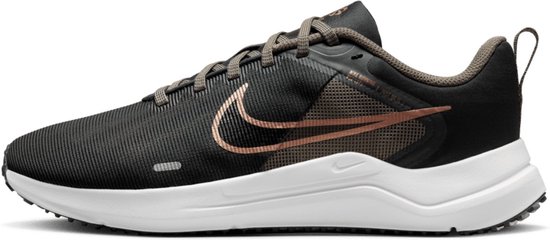 Chaussure de course Nike avec empeigne en mesh noir, swoosh couleur cuivre et semelle blanche.