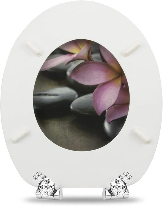 Witte toiletbril met bloemen- en steendecoratie en zilverkleurige scharnieren.