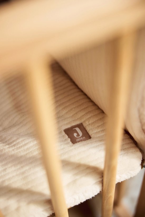 Een beige boxkleed met ribbelpatroon, in een houten box, met een Jollein label.
