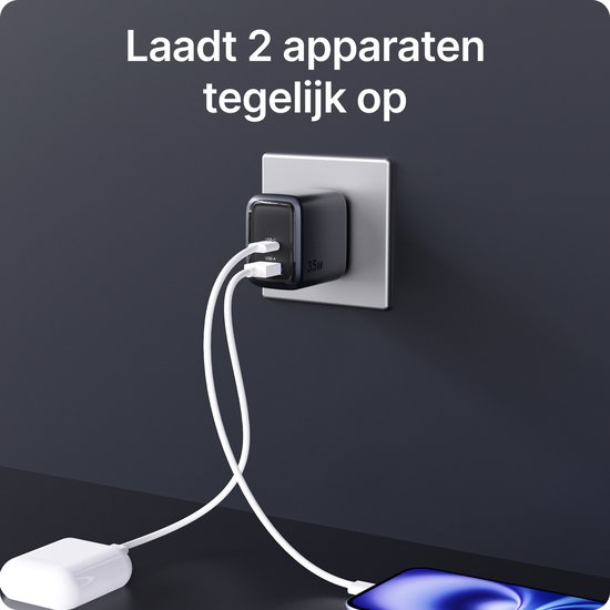 Zwarte 35W snellader met USB-C en USB-A poort, aangesloten op het stopcontact en laadt tegelijkertijd een telefoon en een powerbank op.