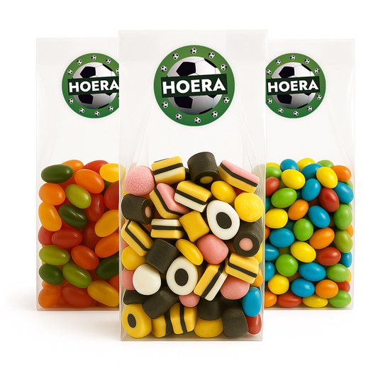 Drie transparante uitdeelzakjes gevuld met snoepjes, elk met een voetbal 'HOERA' sticker.