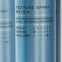 Close-up van een blauwe REF textuursprayfles met informatie over hold, shine en volume.