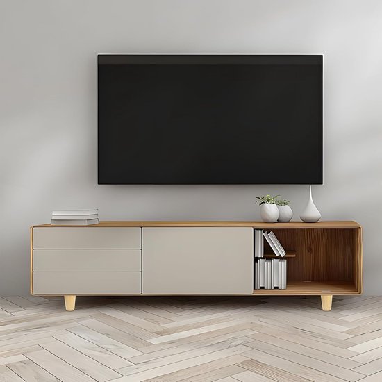 Een strakke, houten en crème TV-kast met vier pootjes, een grote zwarte tv erboven.