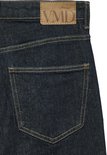 Close-up van de achterkant van een wijde jeans in donker denim met een bruin VMD-merklabel.