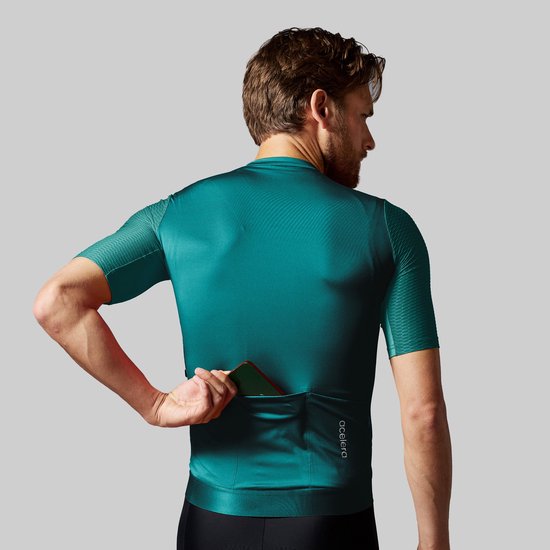 Achterkant turquoise wielershirt met geblokt patroon op de mouwen, een opbergvak en het 'acelera' logo.