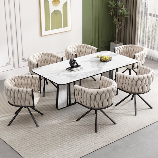 Grande salle à manger avec table rectangulaire en marbre, entourée de six chaises pivotantes en velours beige avec détail de dossier torsadé.