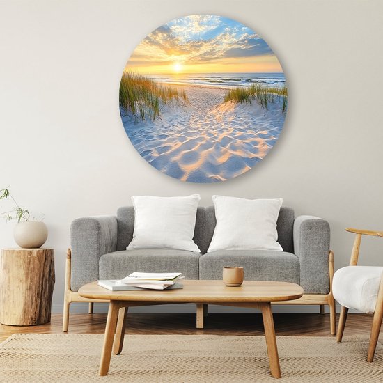 Ronde muurcirkel met een zonsondergang op een strand, met zandduinen en duingras.