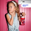 Meisje met haarband houdt een rode drinkfles met vogels en regenboog vast. De fles heeft een handige draaglus.