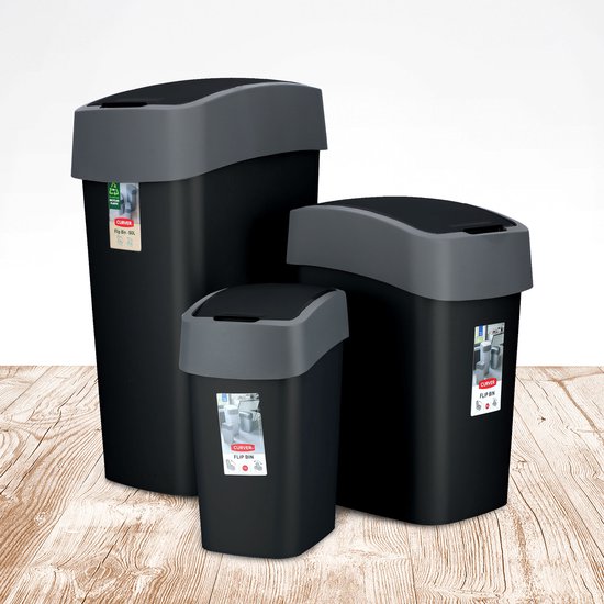 Trois poubelles noires Curver avec couvercles gris sur un sol en bois.