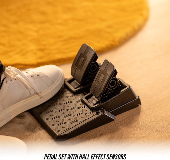 Een witte sneaker op een zwart pedaal met honingraatpatroon. Tekst: PEDAL SET WITH HALL EFFECT SENSORS.