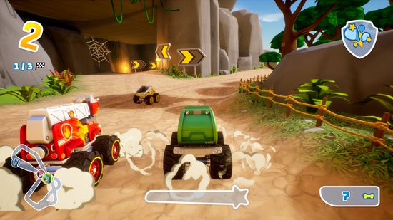 Een PAW Patrol race in een grot en jungle. Een rood met wit voertuig met vuurmotief en een groen voertuig racen op een stoffig pad.