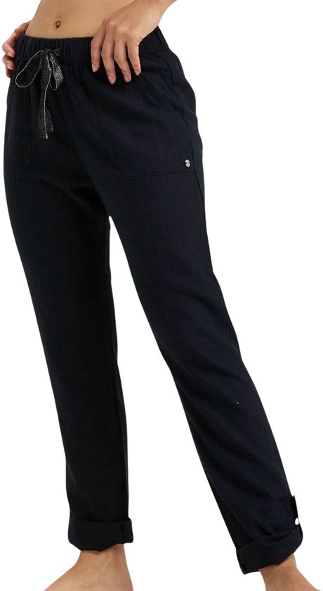 Zwarte broek met ceintuur, opgerolde pijpen en knopen bij de enkel.